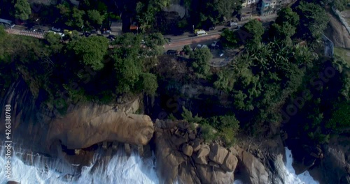 Ocean waves crash on the shoreline, tilt up to reveal the dangerous Vidigal slums in Rio de Janeiro photo