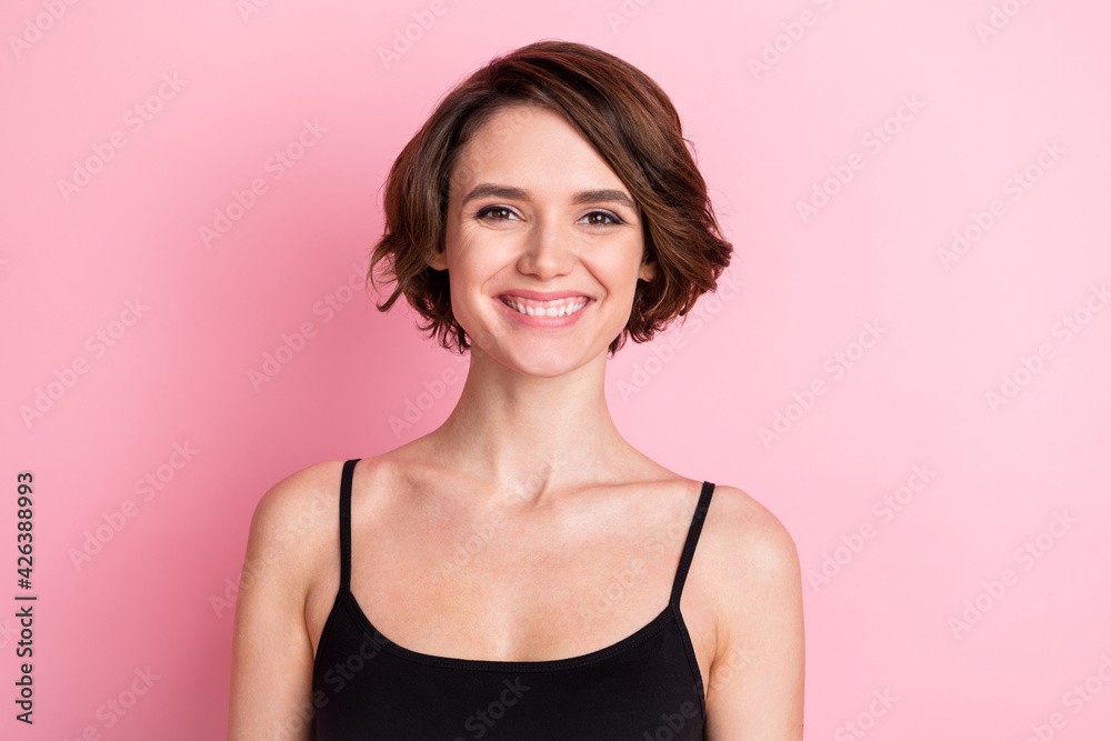 Photo of positive cheerful young woman wear black singlet good mood smile isolated on pink color background Photo of positive cheerful young woman wear black singlet good mood smile isolated on pink color background