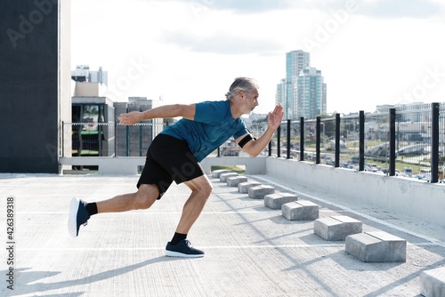 Fitness, workout, sport, lifestyle concept. Middle-aged man running in the city