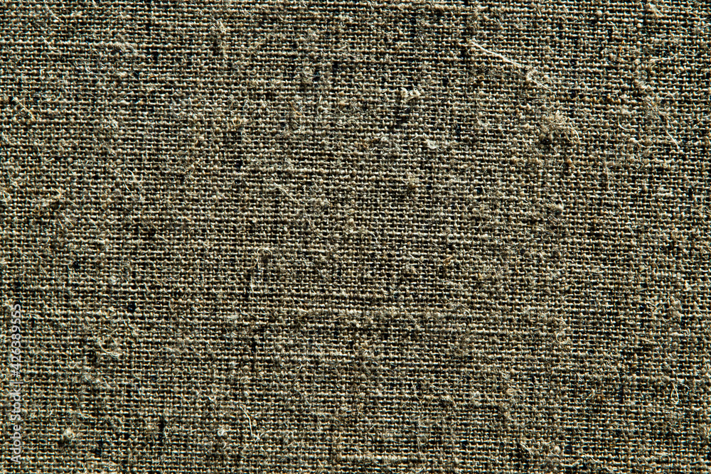dark creative background: reverse side of black-primed linen canvas, uneven lighting, color toning dark creative background: reverse side of black-primed linen canvas, uneven lighting, color toning