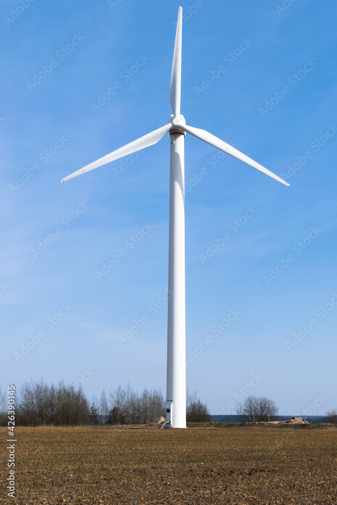 Windmill in a spring field. Alternative energy that does not pollute the environment. Caring for nature. Windmill in a spring field. Alternative energy that does not pollute the environment. Caring for nature.