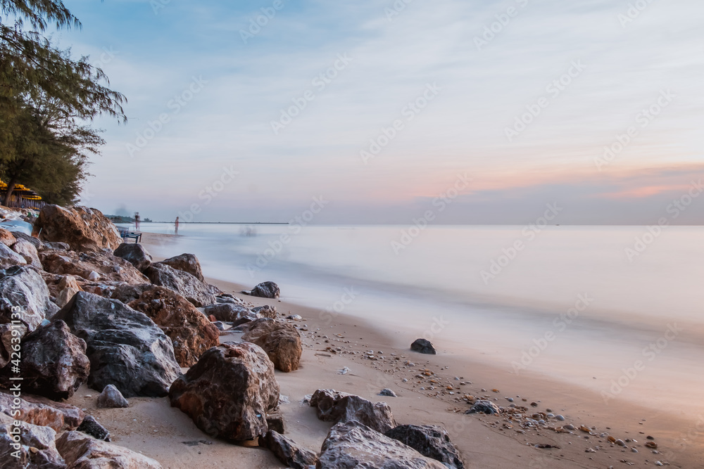 long exposure Sea rocks Magnificent sunrise view at sunrise Romantic atmosphere in peaceful morning at sea. Pink horizon with first hot sun rays.
