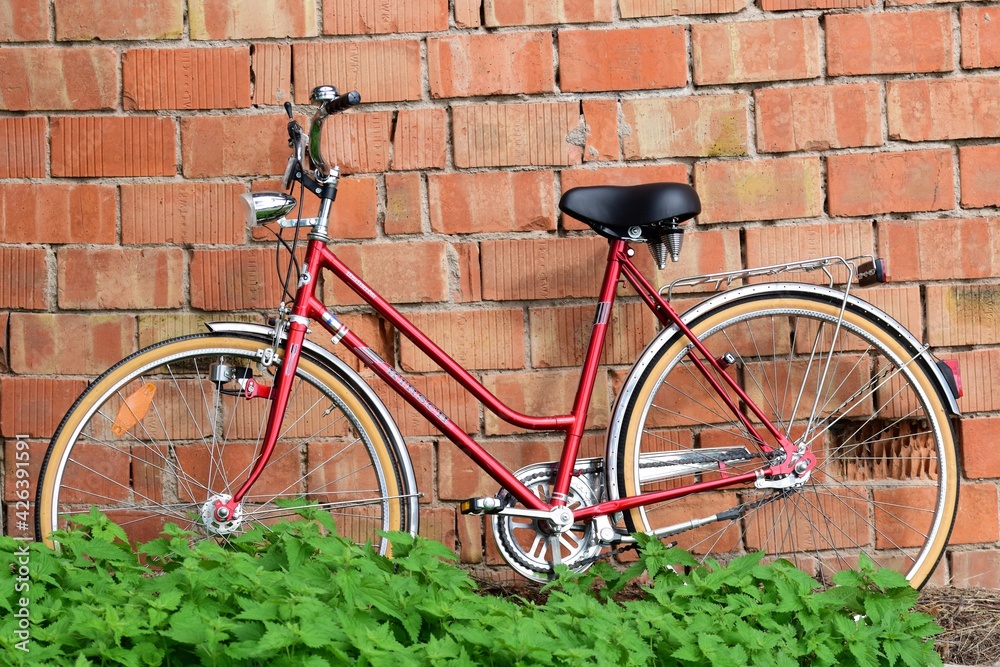 Rotes Fahrrad lehnt an Hauswand