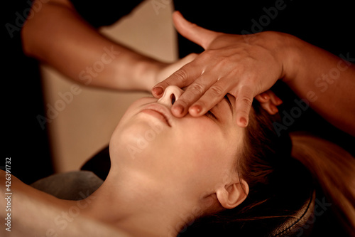 Massage against runny nose and nasal congestion. Healing facial massage in a beauty salon. Wellness facial massage. The concept of alternative medicine.