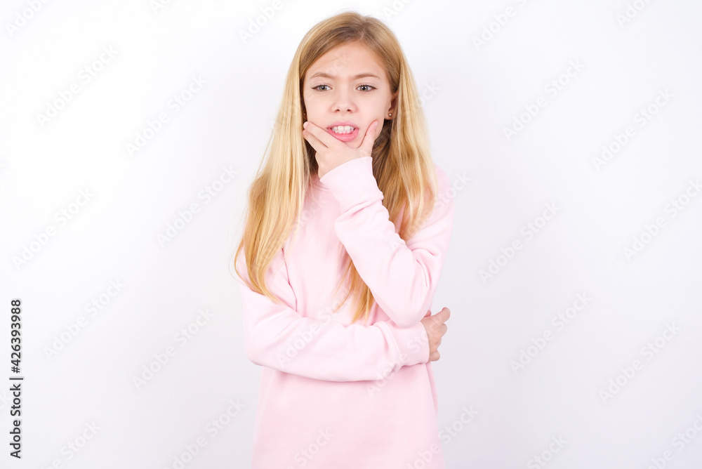 beautiful caucasian little girl wearing pink hoodie over white background covering mouth with hands scared from something or someone bitting nails beautiful caucasian little girl wearing pink hoodie over white background covering mouth with hands scared from something or someone bitting nails