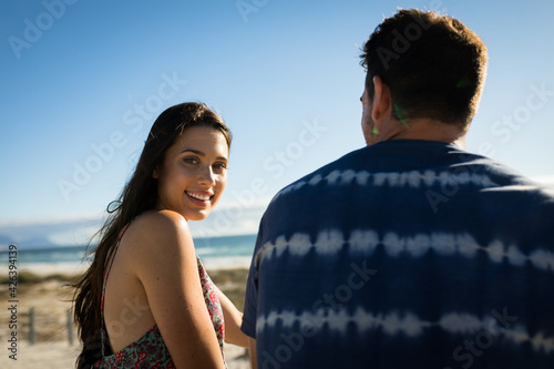 Portrait of caucasian couple on beach, woman looking to camera, smiling