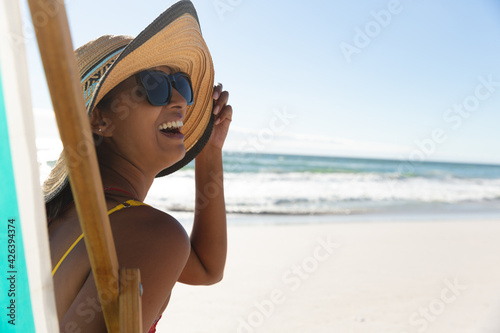 Mixed race happy woman on beach holiday sitting in deckchair © WavebreakMediaMicro
