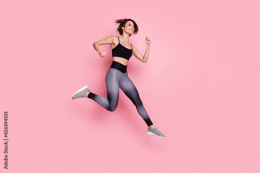 Full body profile side photo of young sportive girl go walk run dynamic jump up training isolated over pink color background Full body profile side photo of young sportive girl go walk run dynamic jump up training isolated over pink color background