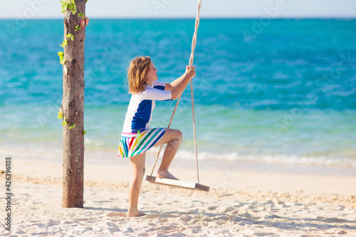 Child on swing. Kid swinging on beach.