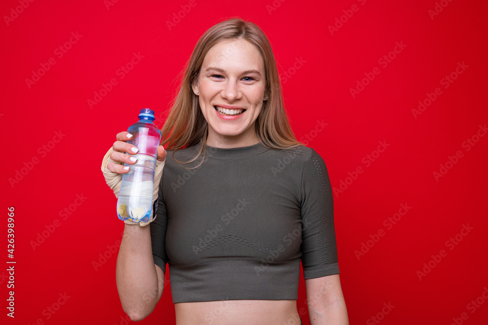 Athletic female boxer drinks water on red background Athletic female boxer drinks water on red background