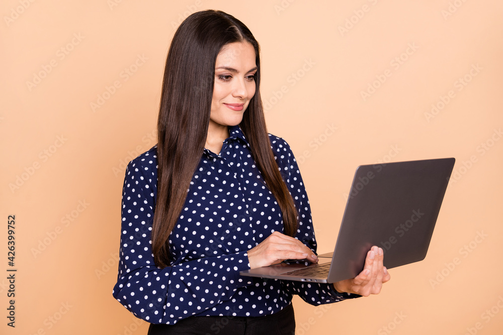 Photo of half turned gorgeous person look laptop smile wear vintage outfit isolated on beige color background Photo of half turned gorgeous person look laptop smile wear vintage outfit isolated on beige color background