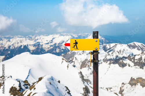 A tourist sign showing a mountain hiking trail from the top of Schilthorn in Switzerland, with the Alps in the background photo