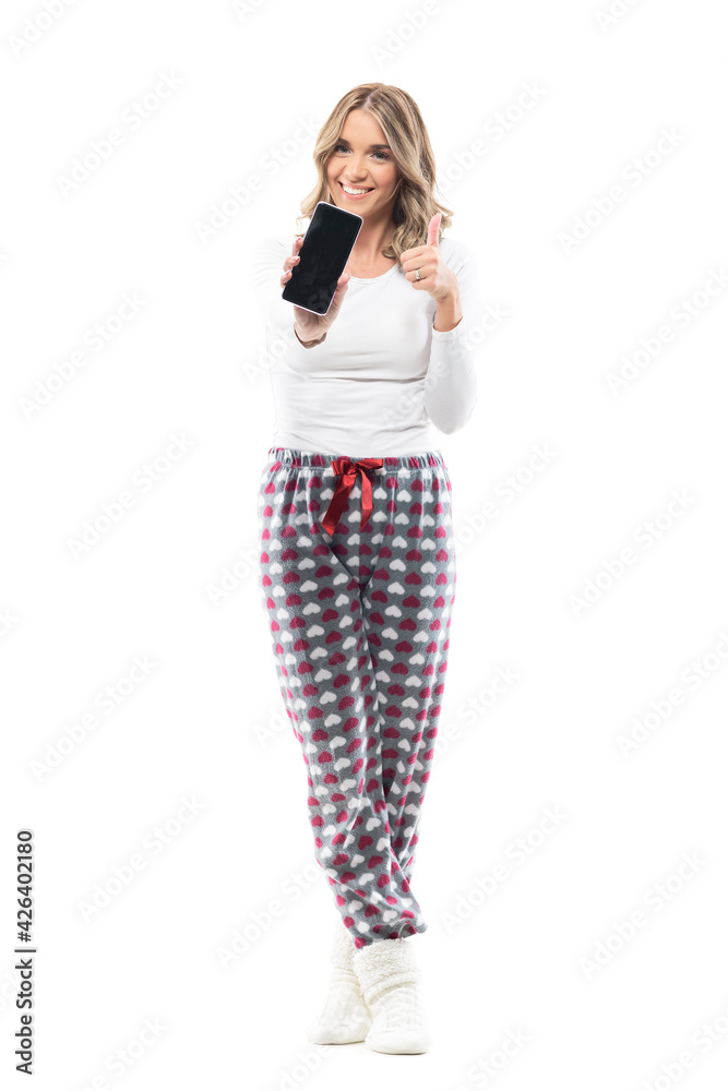 Cheerful excited young woman in home wear clothes showing blank smart phone screen at camera. Full body length isolated on white background. Cheerful excited young woman in home wear clothes showing blank smart phone screen at camera. Full body length isolated on white background.