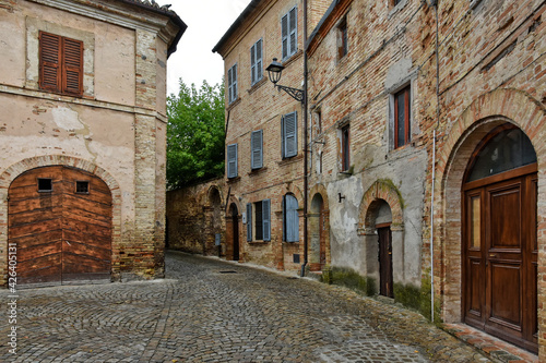 A narrow street between the old houses of Montecosaro, a medieval town in the Marche region of Italy. © Giambattista