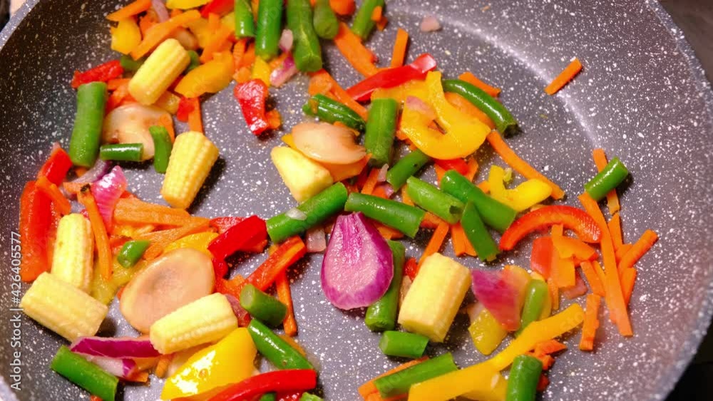 A mixture of frozen vegetables is fried in a pan without oil. Healthy, vegetarian food. A mixture of frozen vegetables is fried in a pan without oil. Healthy, vegetarian food.