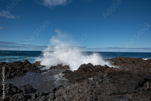 Seelandschaft mit schwarzen Felsen und der brechenden Welle bei La Fajana im Norden von La Palma