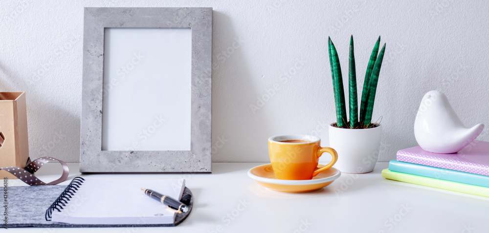 Cozy home office on white  table , fountain pen, ribbon, yellow cup of coffee, frame with space for tekst,  notebook  Background with copy space. Elegant feminine workspace.  - obrazy, fototapety, plakaty 