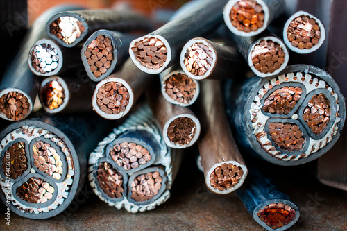 Macro photo of many copper wires twisted into rods and covered with plastic or gum isolation. Isolated copper wire endings cutted in half lying on a pile. © Patrycja