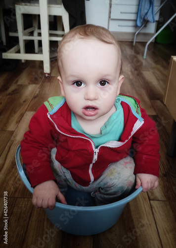 baby child sitting in a washbowl