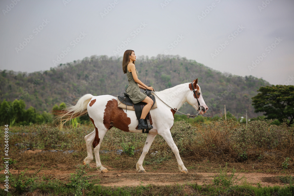 Women on skirt dress Riding Horses On field landscape Against Sky During Sunset