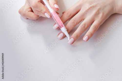 Картината върху платно Female hands with pastel trendy manicure moisturizing cuticle.