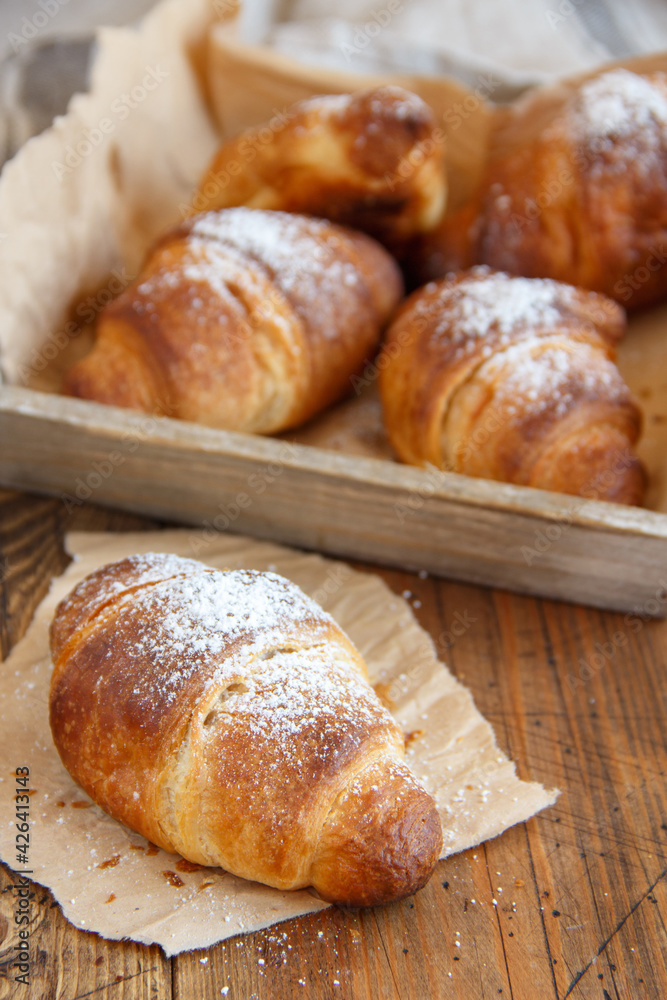 French fresh crusty croissants on a wooden table