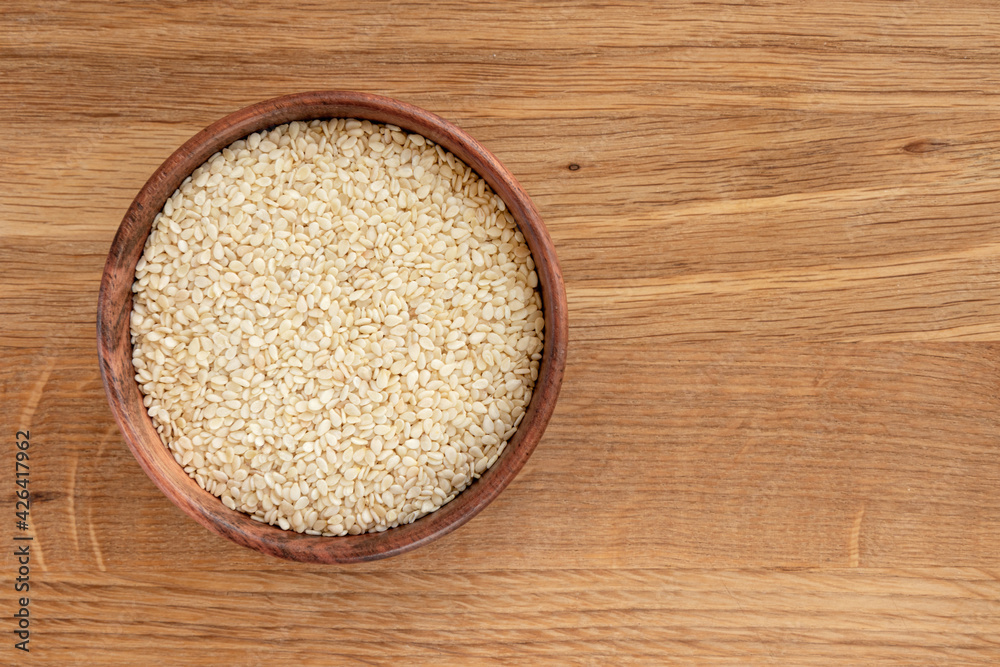 sesame seeds in bowl on wooden background, top view sesame seeds in bowl on wooden background, top view