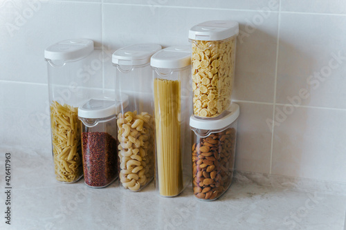 A variety of pasta, rice, cereals, nuts in containers-cans. The concept of proper convenient rational storage of food in the kitchen