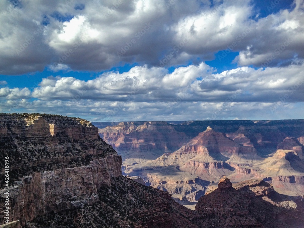 Puffy white clouds in the Grand canyon valley, fantastic view, canyon background