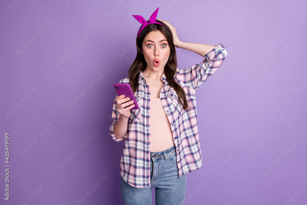 Photo portrait of amazed shocked girl reading fake news on cellphone isolated on bright purple color background