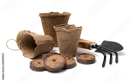 biodegradable peat pots, peat tablets, garden tools and rope isolated on white background. spring gardening concept. Growing homemade herbs and vegetables.