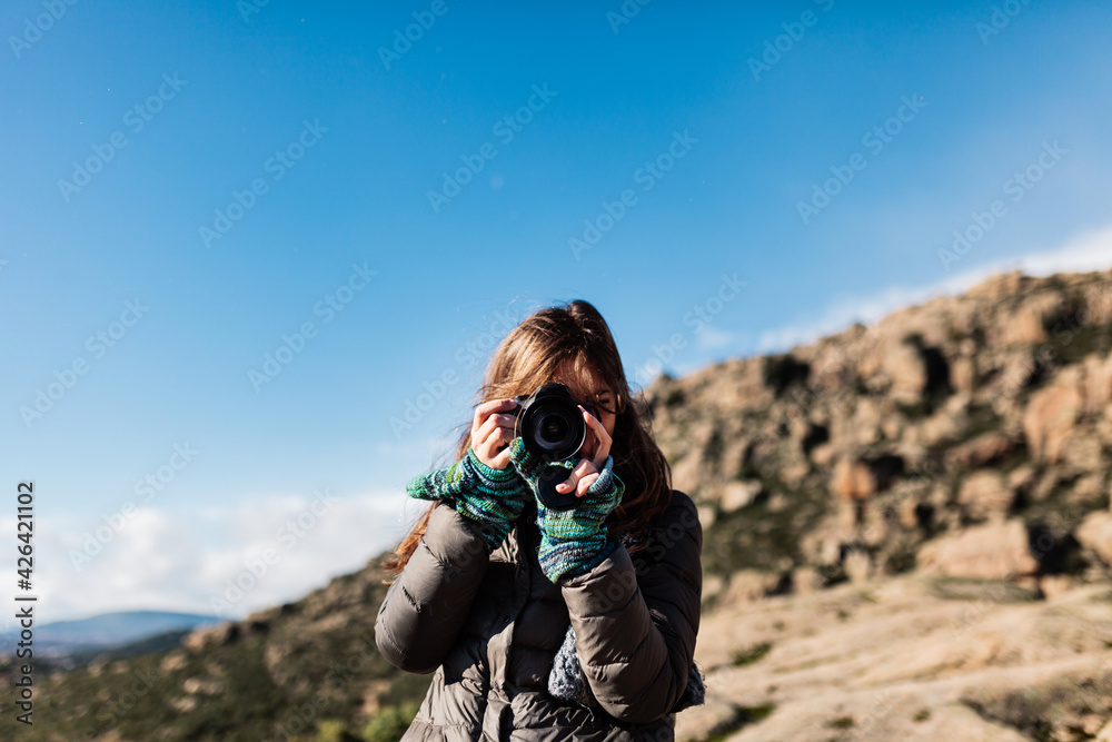 young woman taking photos in the nature