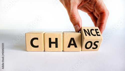 Chance or chaos symbol. Businessman turns a cube and changes the word 'chaos' to 'chance'. Beautiful white background, copy space. Business, chaos or chance concept.