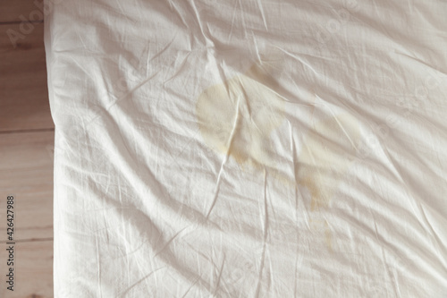 Image of pee's child on the white bed sheet. Cause stains and dirty on the mattress. photo
