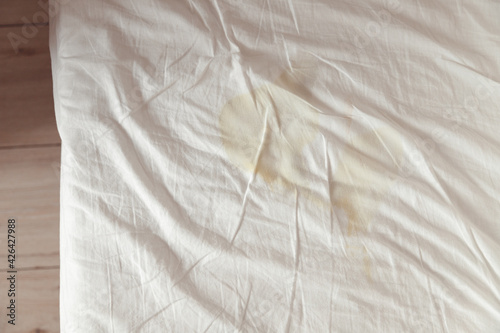 фотографія Image of pee's child on the white bed sheet