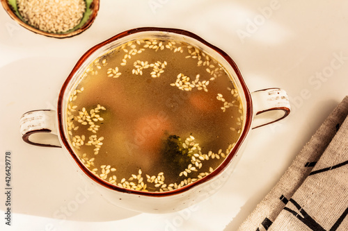 Top view of homemade soup with sesame seeds in white soup bowl. Healthy lunch, dinner. Stock photo, copy space