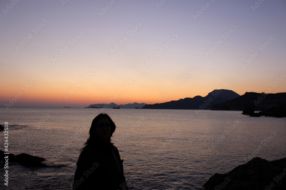 Woman enjoying a Mediterranean sunset in Cala Cortina