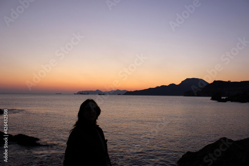 Woman enjoying a Mediterranean sunset in Cala Cortina