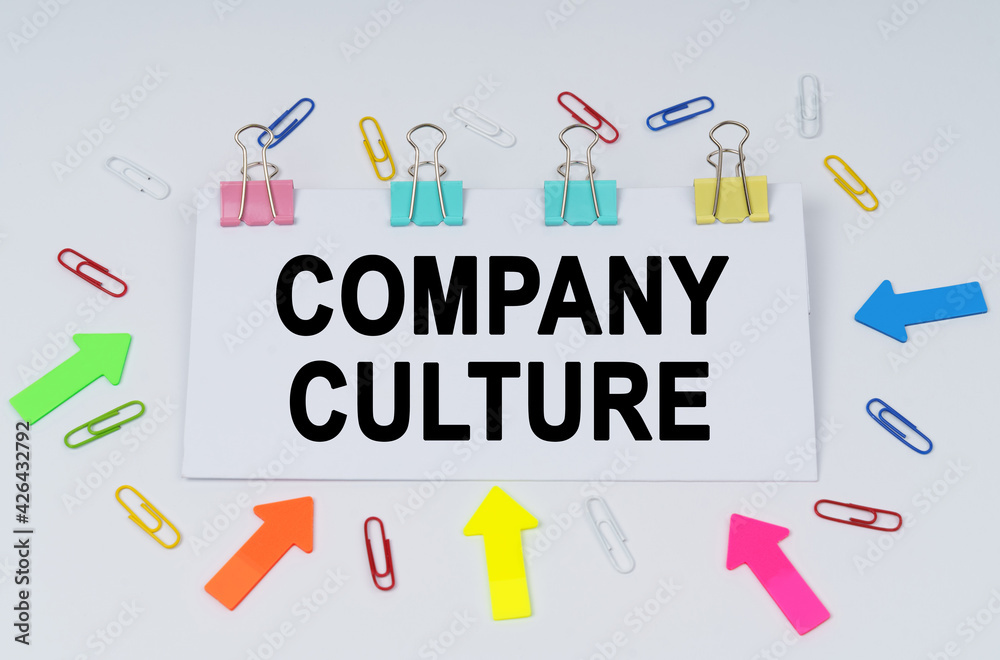 On the table there are paper clips and directional arrows, a sign that says - Company Culture On the table there are paper clips and directional arrows, a sign that says - Company Culture