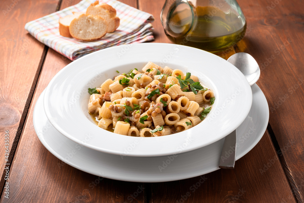 Piatto di deliziosa pasta con lenticchie e pancetta, cucina italiana