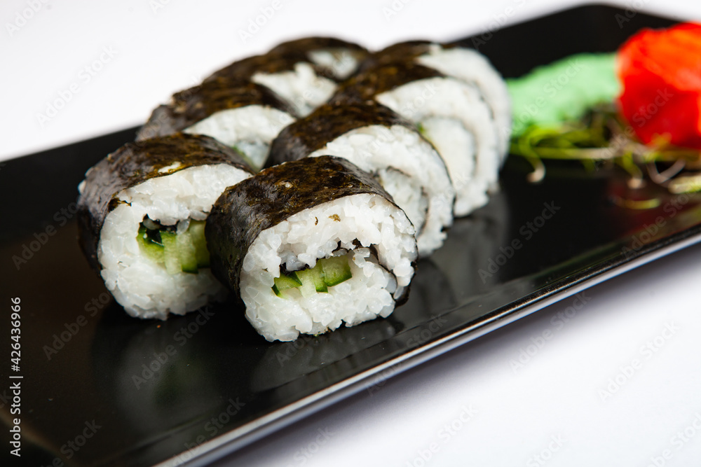 Japanese food rolls in plastic box. Sushi set in a plastic package close up isolated on a white background. Sushi for take away or sushi delivery. Japanese food rolls in plastic box. Sushi set in a plastic package close up isolated on a white background. Sushi for take away or sushi delivery.