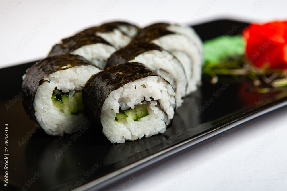 Japanese food rolls in plastic box. Sushi set in a plastic package close up isolated on a white background. Sushi for take away or sushi delivery. Japanese food rolls in plastic box. Sushi set in a plastic package close up isolated on a white background. Sushi for take away or sushi delivery.