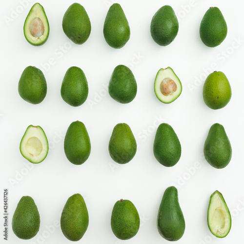 Avocado whole and half on white background. Flat lay, top view