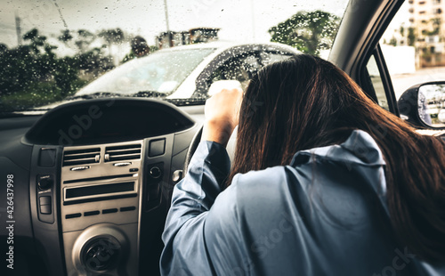 A woman driving and having a accident car crash, while raining and recklessness, to people and transportation insurance concept.