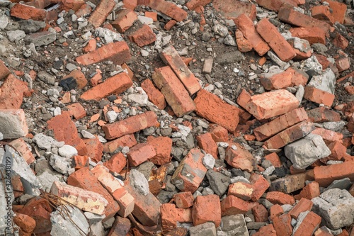 Background with a pile of old red bricks, shards of concrete and rebar. Construction garbage