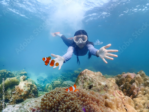 Young femal diving with snorkel and fins to see nemo fish and coral at Samaesarn Island of Thailand photo