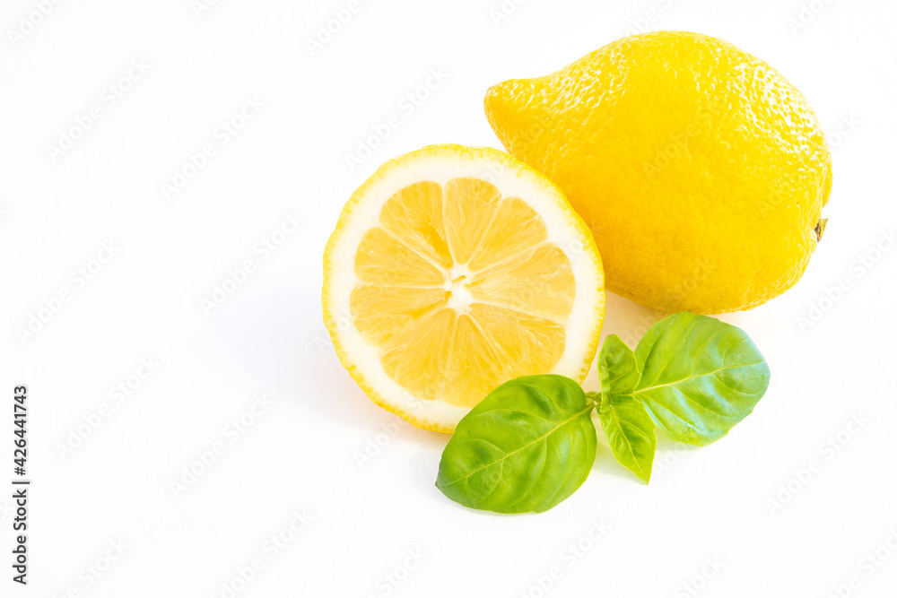 Whole yellow lemon fruit with half lemon isolated on white background with leaf and copy space Whole yellow lemon fruit with half lemon isolated on white background with leaf and copy space