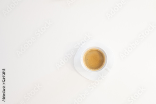 Close up top view of a white porcelain cup of coffee shoot from above isolated on white background with copy space