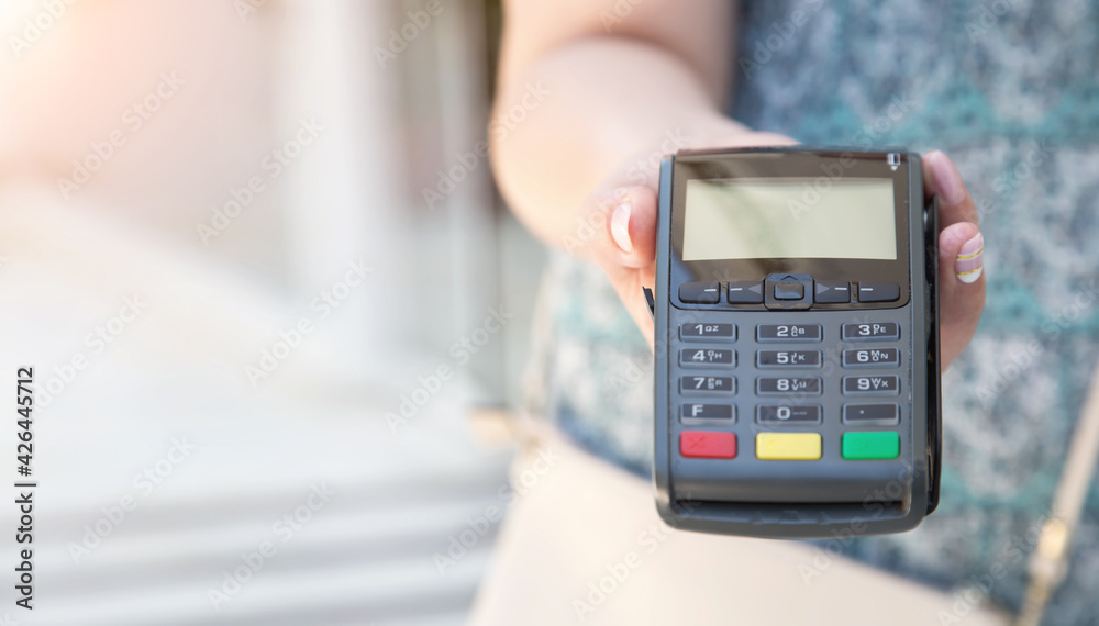 Close-up female hand using swiping machine to pay credit card. Private businessman and cashless settlement. Self employed. Offer to pay by credit card by bank transfer. Close-up female hand using swiping machine to pay credit card. Private businessman and cashless settlement. Self employed. Offer to pay by credit card by bank transfer.