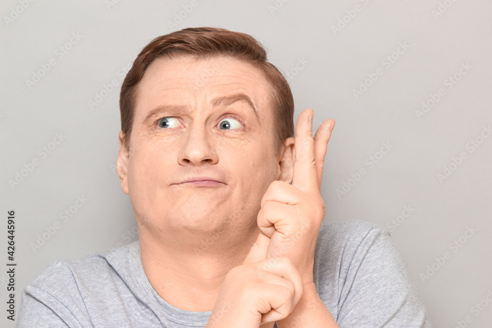 Portrait of funny mature man making list of something with fingers Portrait of funny mature man making list of something with fingers